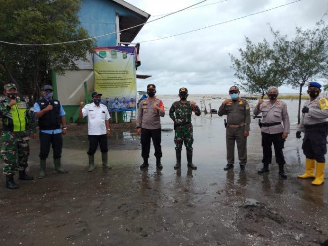 
 Putus Mata Rantai Covid-19, Polsek Muara Gembong Pasang Spanduk PPKM di Lokasi Wisata Pantai Bungin